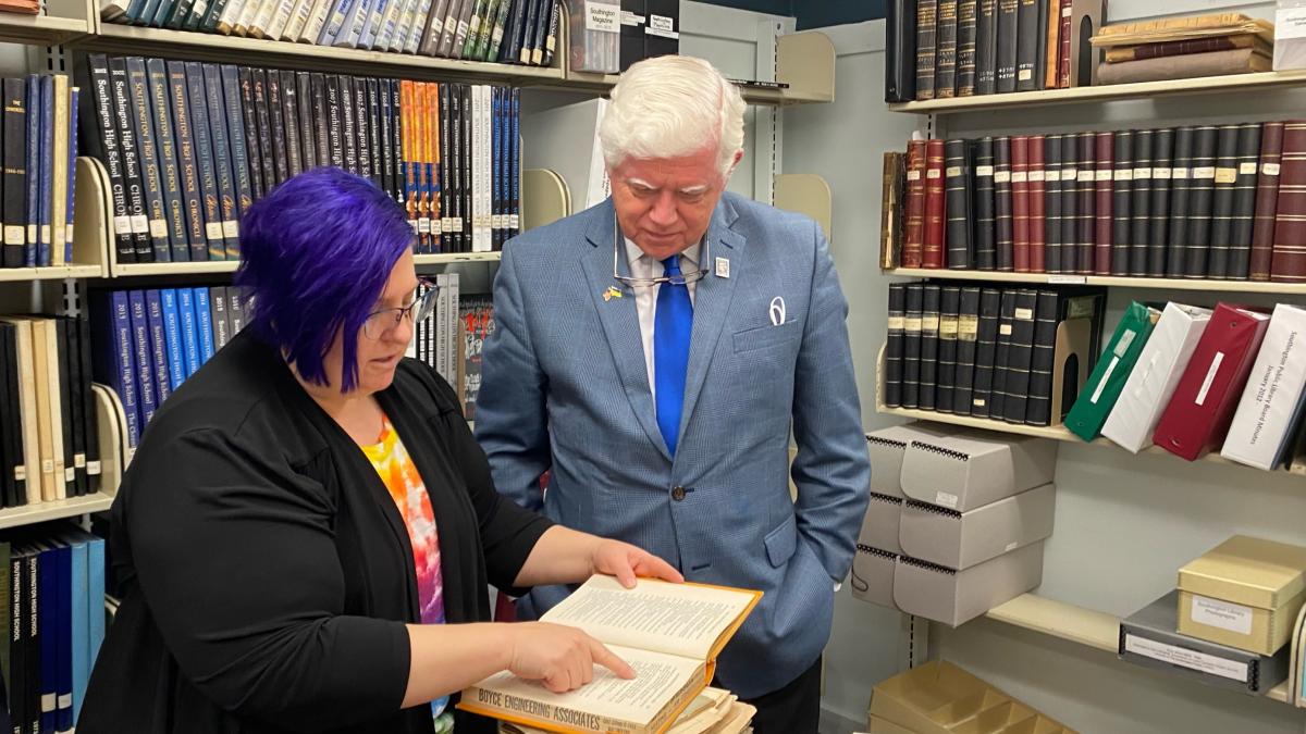 Larson looks at library archives with Reference Librarian Lynn Gardner
