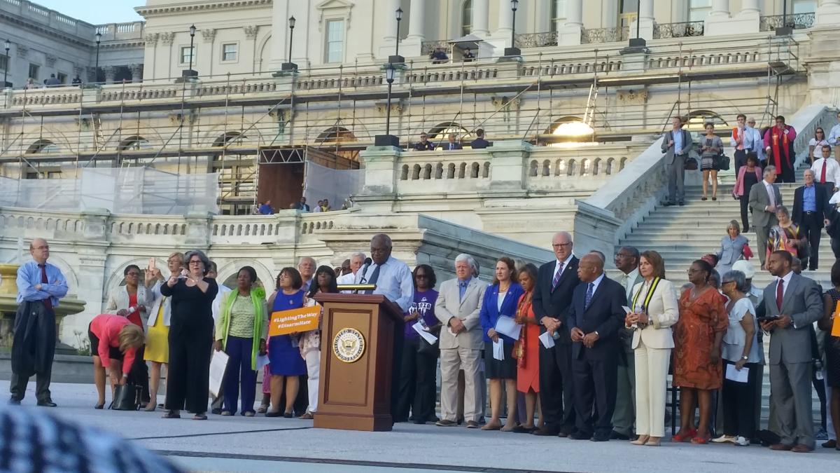 Larson stands with activists and lawmakers on the Capitol steps