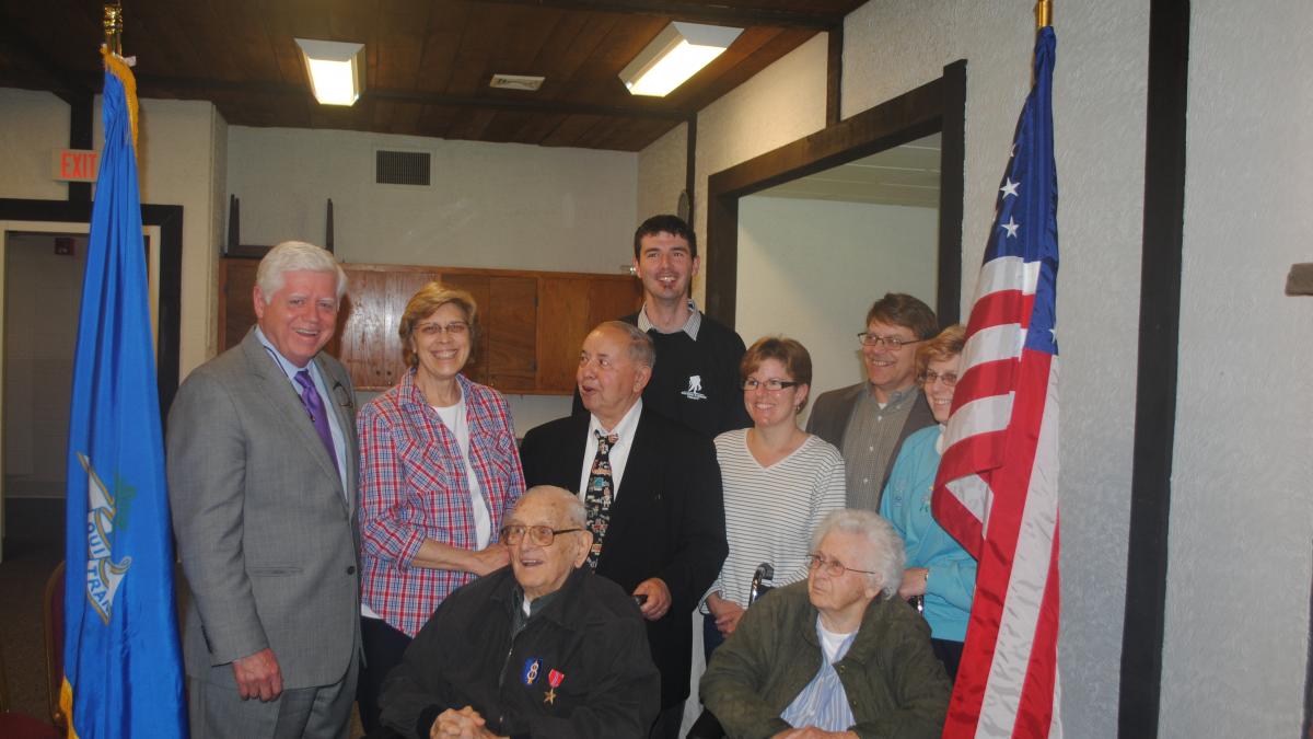 Larson stands with Mr. and Mrs. Luszczak, their son Tom, and other family and friends 
