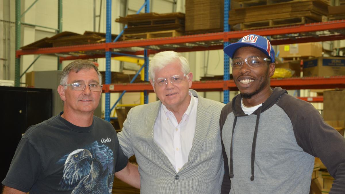 Larson stands with workers at ATI