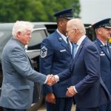 President Joe Biden shakes hands with Rep. John Larson, D-Conn., second from left, as he arrives at Bradley International Airport in Windsor Locks on Friday. Gov. Ned Lamont looks on at left.